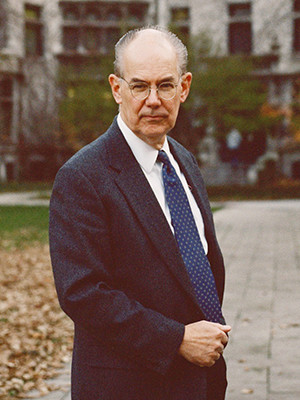 man about 60 wears a blue suit white shirt blue tie.