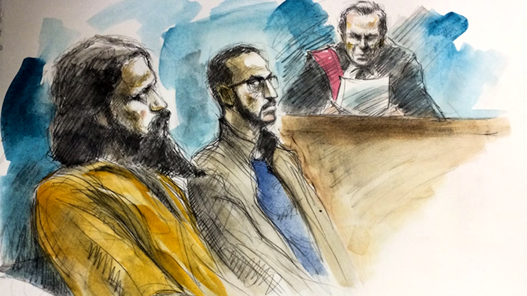 Man with long beard. stern look - judge seems angry. Two men in prisoners box. accused of terror to blow up a via rail passenger train